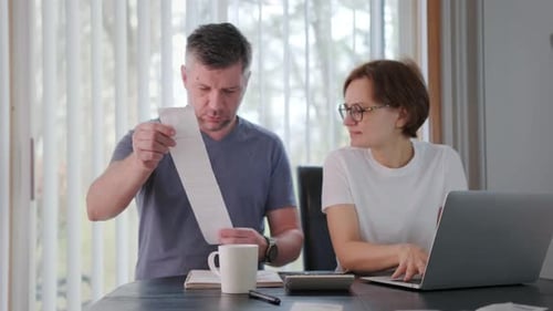Woman and Man with a Dog Together Checking Bills Taxes Bank Account Balance and Calculating Expenses