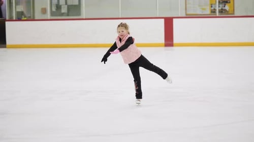 Young Girl Ice Skating and Spinning on Rink