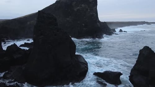 Aerial Seascape South Coast of Iceland. Waves Crashing to Black Rocks on Shore