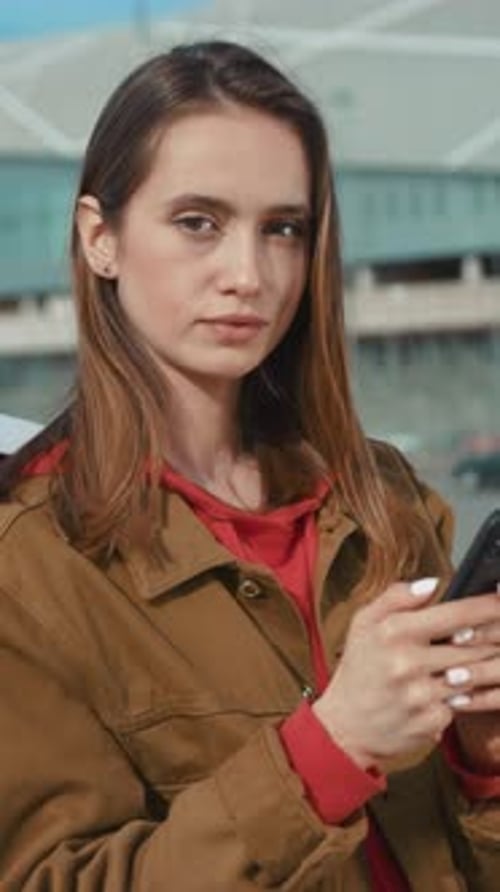 Young Woman Uses Mobile Phone in Urban Setting