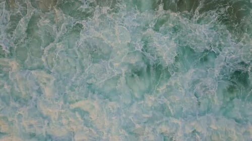 Energía dinámica: olas del océano que se agitan en el mar, vista aérea, remolinos de espuma del océano