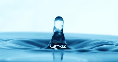 Drop of water falls into a drop of water in a super slow motion. Shot on super slow motion camera