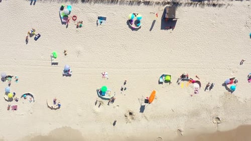 Beach showing colourful umbrellas and people relaxing on a summer day. Baltic Sea. Aerial view. Hel