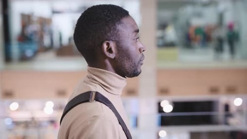 A Young African Man is Walking Through the Mall