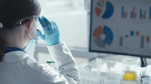 Dans un laboratoire moderne, un scientifique dévoué analyse des données complexes à l'aide de technologies avancées pour améliorer