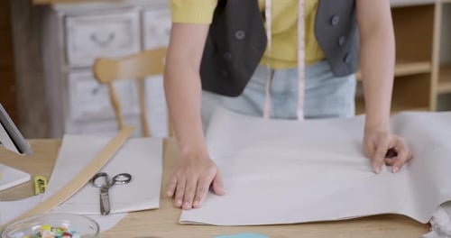 Woman Designs Dress with Paper Pattern and Ruler