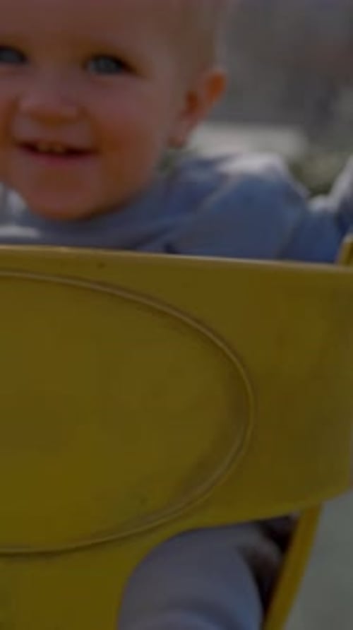 Happy Infant on Swing at Sunny Playground