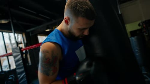 Boxing gym a boxer trains his punches hitting a punching bag