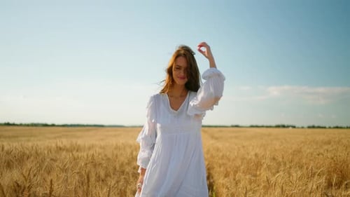 Woman in White Dress Walking in Golden Field