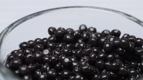 Black Caviar in Glass Pot Closeup Beluga Sturgeon Salted Roe in Glass Bowl Raw Seafood Luxury