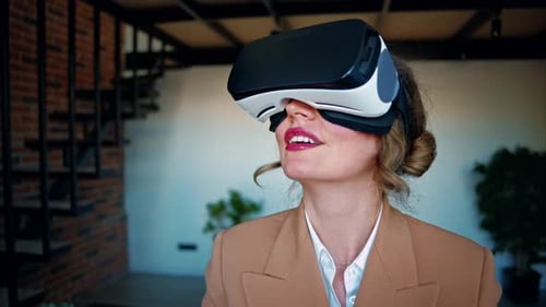 Woman smiling while using a Virtual Reality headset in an office
