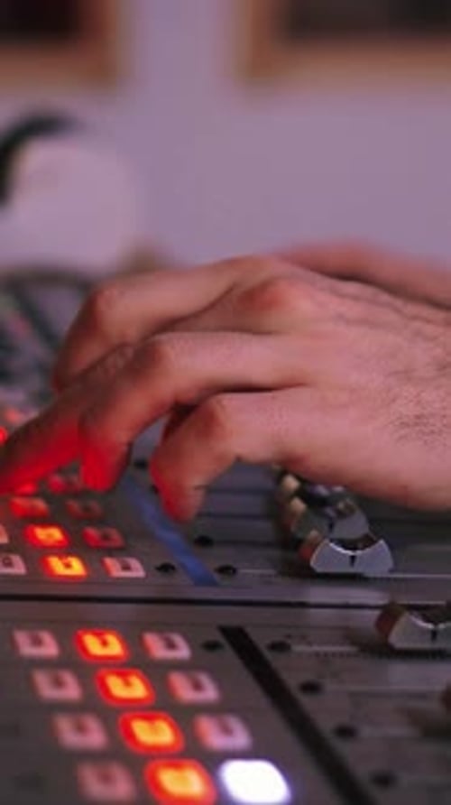 Vertical Close Up Portrait of Hands Working on Sound Mixer Console for Recording Broadcasting or