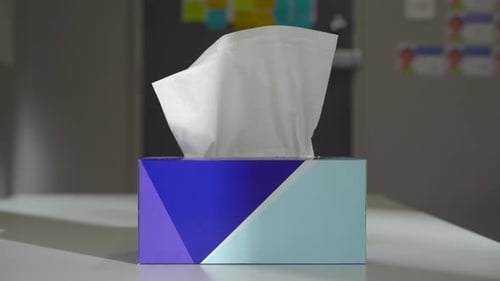 Hand taking multiple tissues from a tissue box