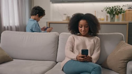Woman and Boy Using Smart Phones at Home
