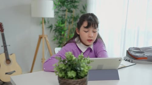 Focused Girl Studying with Tablet Device at Home