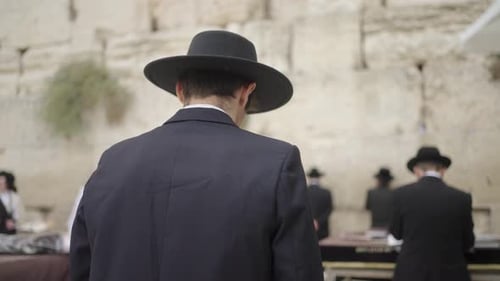 Religious Orthodox Jewish Men Praying With Torah At Western Wall In Jerusalem, Israel. medium shot,