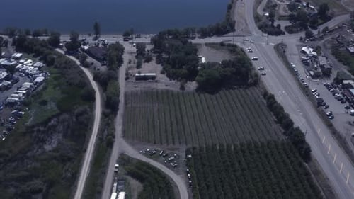 aerial panout drop over RV lakeside resort acorss vineyards wine processing plants, alcohol reatil s
