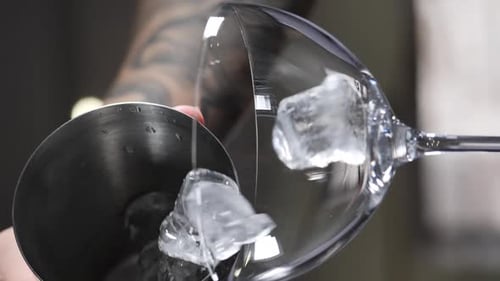 Ice Cubes Falling Into Empty Glass Making Cocktail in Nightclub Bar Vertical Footage Adding Ice Slow