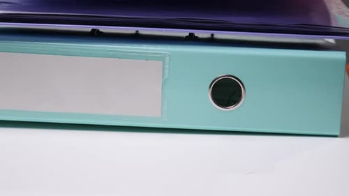 Stapeln Sie einen hellblauen Ordner mit leerem Etikett und Ringmechanik sowie anderen farbenfrohen Ordnern