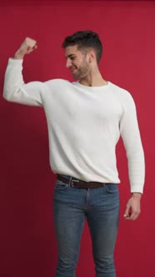 Smiling Man Flexing Muscle on Red Background