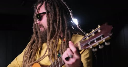 Guitarist Man Plays an Acoustic Guitar Closeup at Studio
