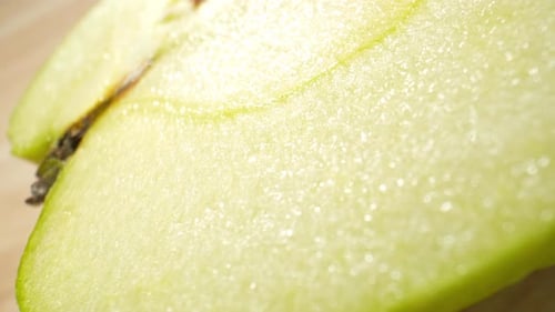 The camera focuses on the half green apple. Macro footage