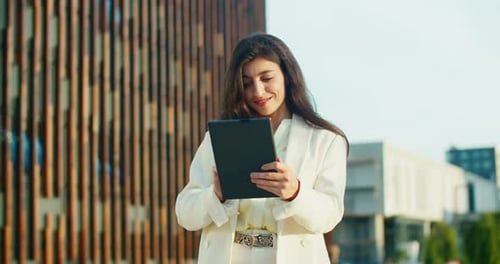 Young Woman Using Tablet Outside Building
