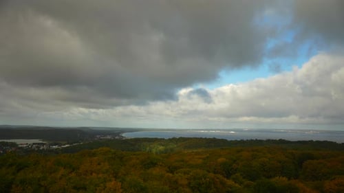 aerial view of rügen germany with moving clouds sun shining on forest and sea background