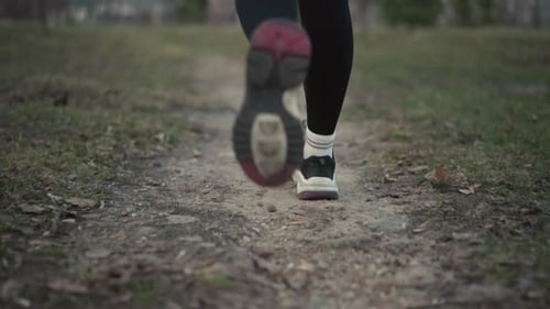 Young Woman Running Toward Camera On Narrow Forest Track Red Hoodie Visible Rhythmic Footfalls On