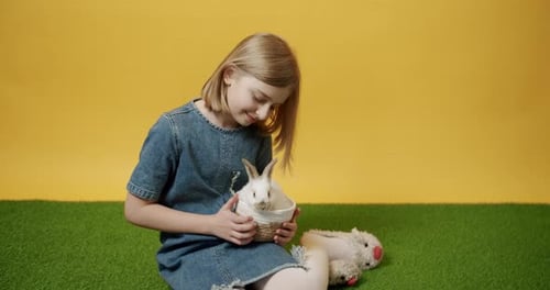 Girl Cradles Rabbit Lovingly in Basket on Lawn