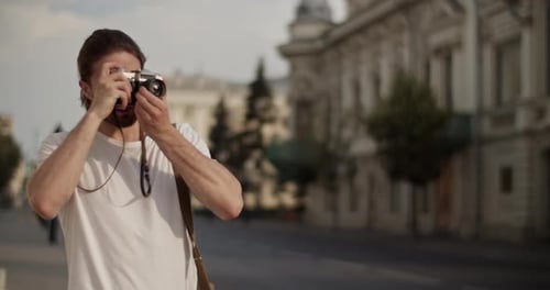 Male Tourist Taking Photos on City Street During Trip