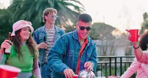 Young Friends Celebrate with Disco Ball at Rooftop Party