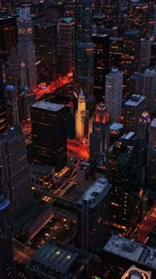 Aerial view of illuminated skyscrapers and city streets at night in Chicago