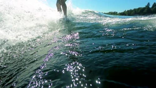 Slow motion of wake surfer making a small cut while riding a wave.