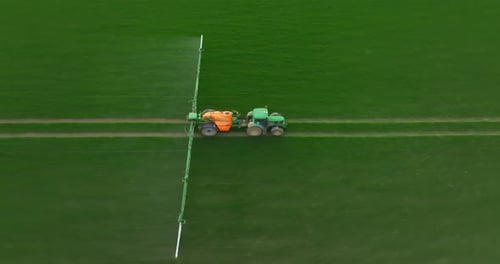 Vista aérea de un tractor autónomo autónomo con piloto automático rociando fertilizante nitrogenado mineral o