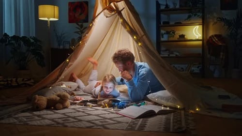 Parent and Child Reading in Cozy Lit Tent