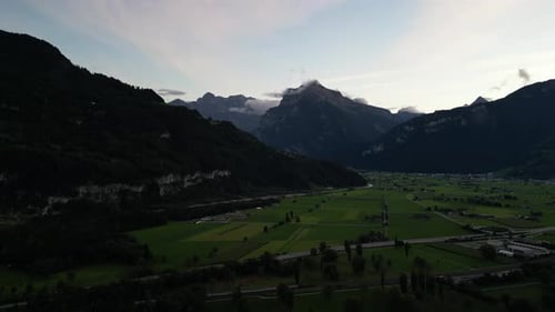 Drone views of green meadows, train transportation, settlements and mountains in canton St. Gallen a