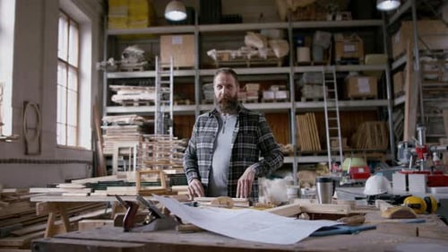 Bearded Carpenter with Arms Crossed in Woodshop