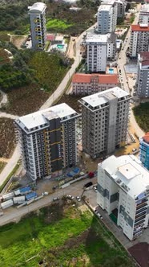 Vídeo vertical: Building Momentum: vista aérea de un sitio de construcción de varios pisos en pleno apogeo