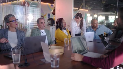 Business Team Analyzing Data on Laptops During Meeting in Modern Office