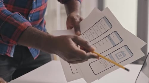 Mobile App Developers Discussing UX Design Sketches