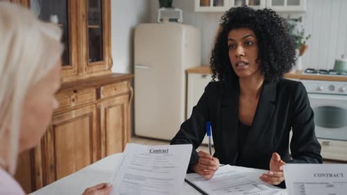 Business Woman Explains Contract Terms to Senior