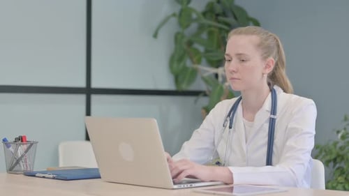 Female Doctor Working on Laptop in Clinic
