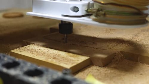 CNC machine cutting wooden board in closeup image. Homemade CNC machine working on the wooden board.