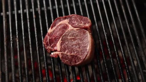 Red Meat Sizzling on a Hot Black Grill
