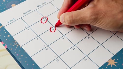 Circling Date on the Calendar with Red Pen