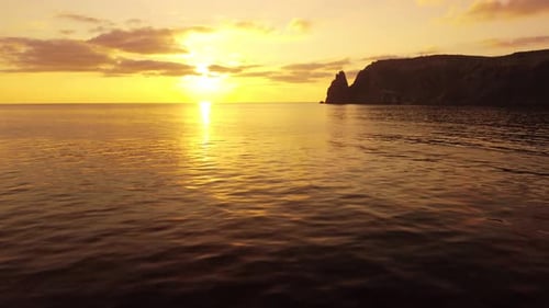 Aerial View on Sunset Over Calm Sea and Volcanic Rocky Shores