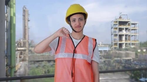 Upset Indian female construction worker showing thumbs down