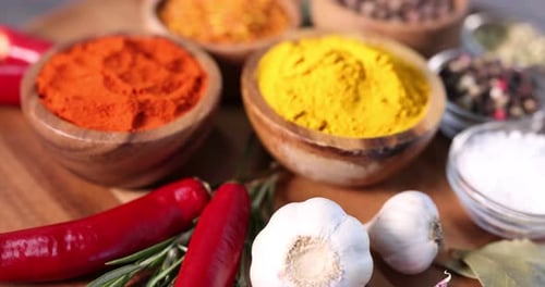 Colorful Spices in Bowls Rotating on Wooden Board