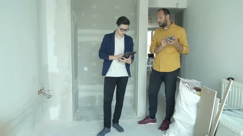 Father and Son Working with Smartphone and Tablet at Their New Home Adult